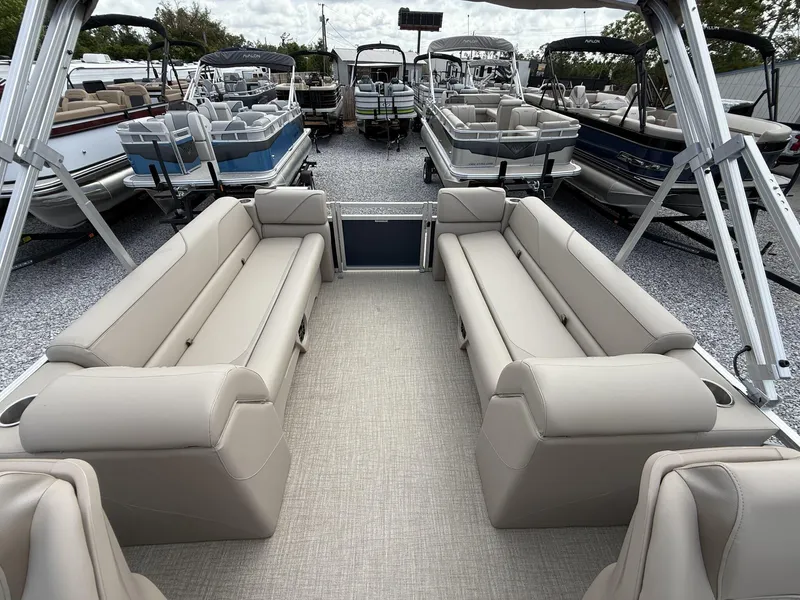 Slide: The Image of 2025 Avalon VENTURE 23 QUAD LOUNGER interior with beige seating, displayed among other boats. - 5