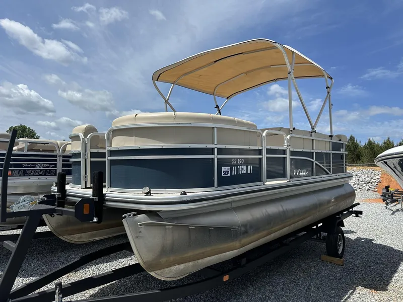 Slide: The Image of 2015 Lowe SS190 pontoon boat with canopy on trailer under blue sky. - 1