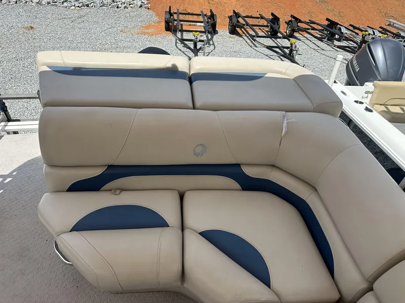 Slide: The Image of 2015 Lowe SS190 boat seating with beige and blue upholstery, parked on gravel. - 4