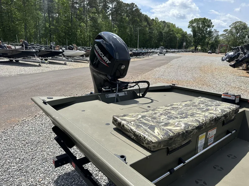 Slide: The Image of 2024 Tracker Grizzly 1860 CC boat with Mercury engine, parked on gravel lot under clear sky. - 3