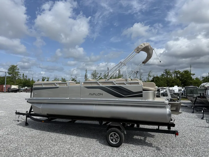 Slide: The Image of 2025 Avalon Venture 21 CRUISE pontoon boat on trailer under cloudy sky. - 2