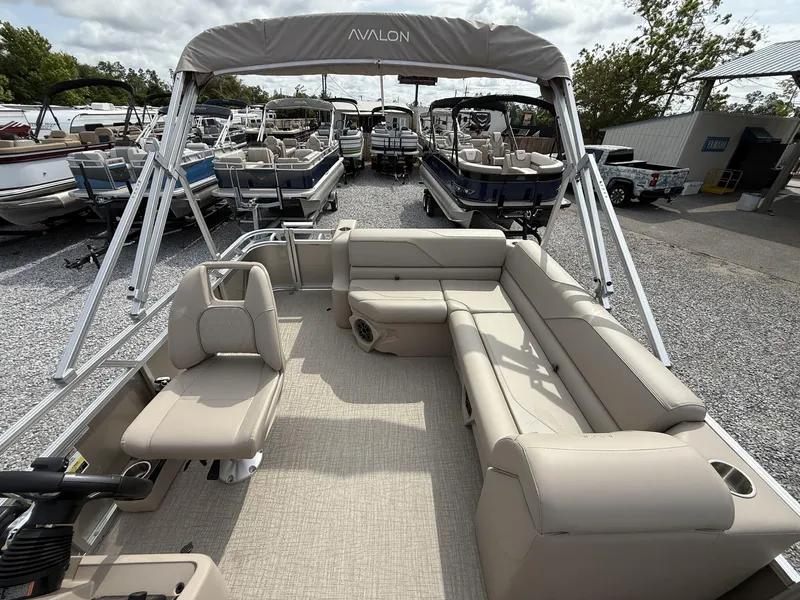 Slide: The Image of 2025 Avalon Venture 21 CRUISE pontoon boat with beige seating and canopy, displayed outdoors. - 4