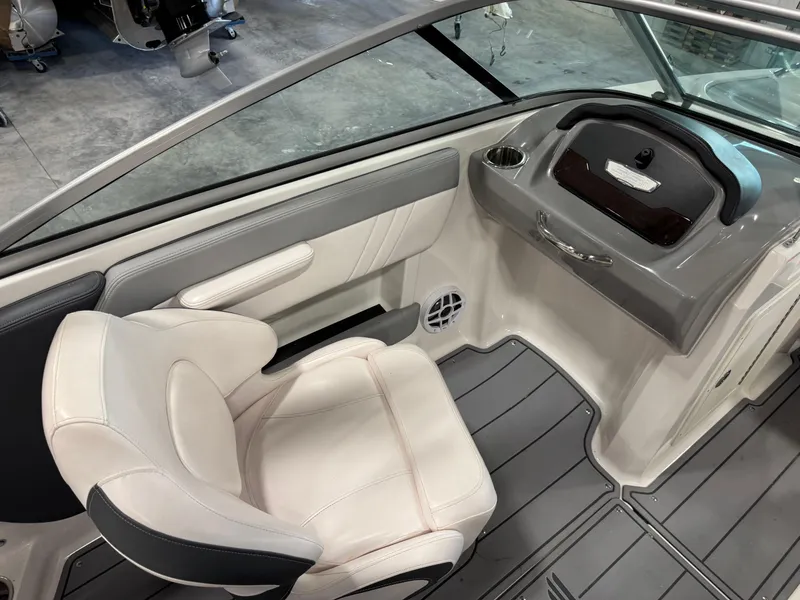 Slide: The Image of 2021 Chaparral 21 SSi boat interior with white seating and sleek dashboard design. - 12