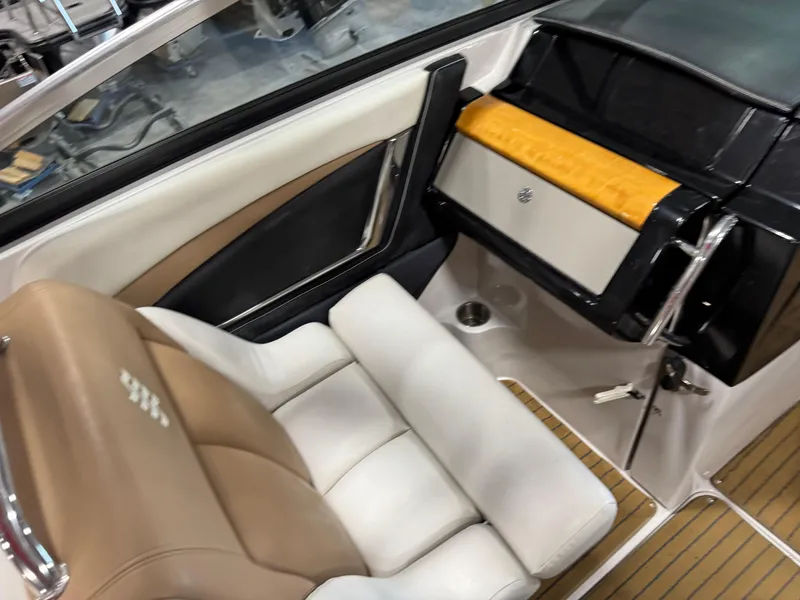 Slide: The Image of 2008 Four Winns SL 262 boat interior with tan and white seating, sleek dashboard design. - 11