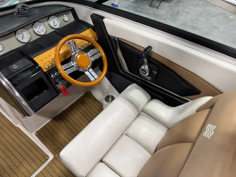 Slide: The Image of 2008 Four Winns SL 262 boat interior with wood-accented steering wheel and beige seating. - 12