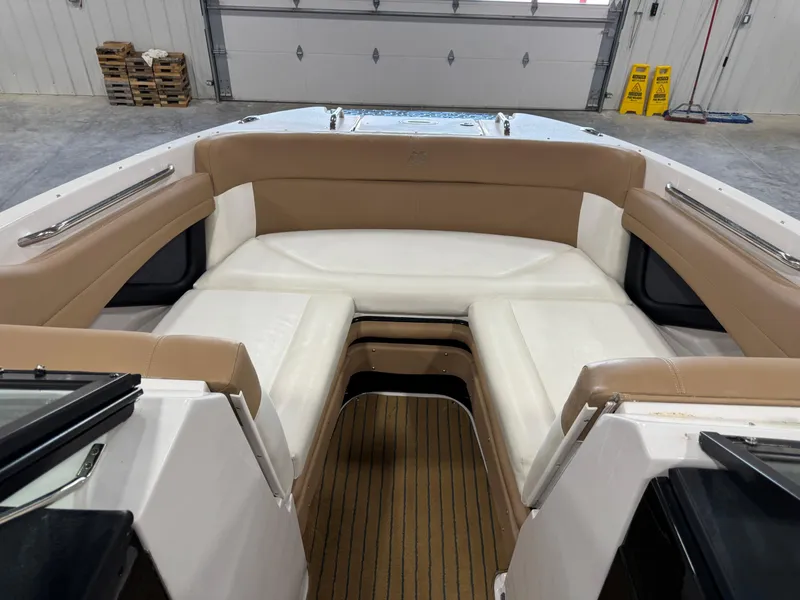 Slide: The Image of 2008 Four Winns SL 262 boat interior with tan and white seating in a garage. - 13