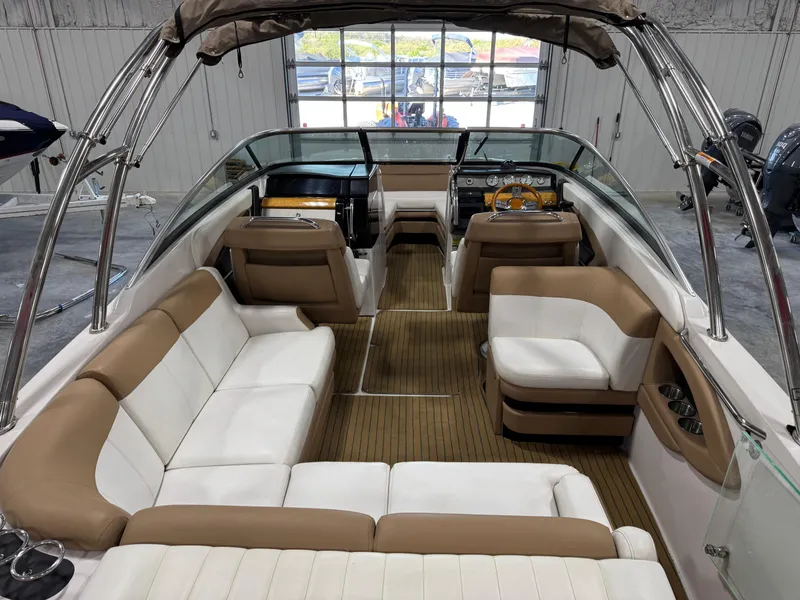 Slide: The Image of 2008 Four Winns SL 262 boat interior with beige and white seating, wood flooring, and steering console. - 7
