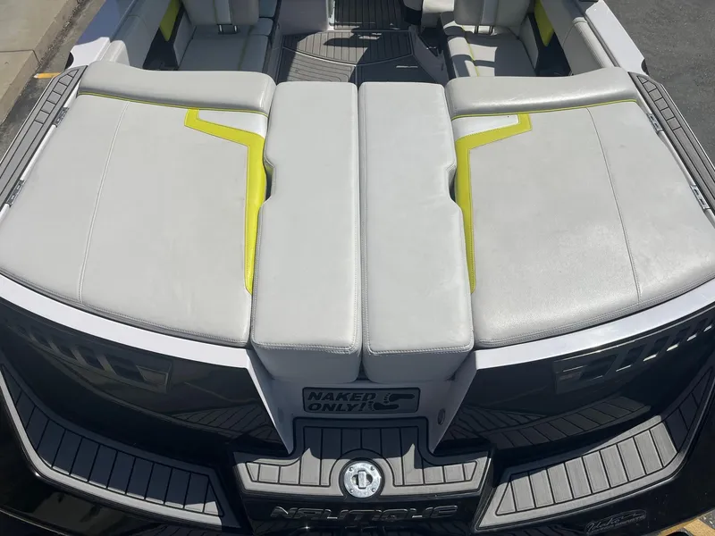 Slide: The Image of 2014 Nautique 230 TEAM EDITION boat with gray and yellow seating, rear view. - 15