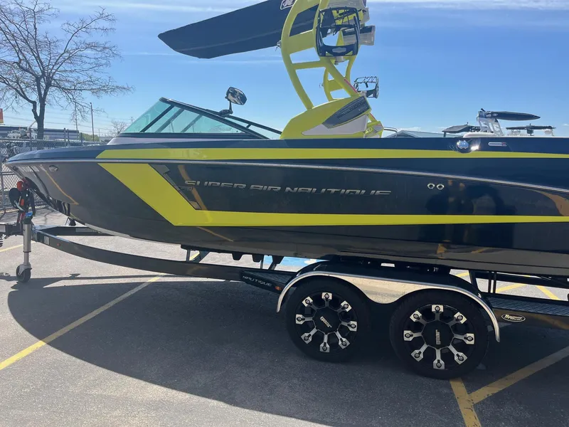 Slide: The Image of 2014 Nautique 230 TEAM EDITION boat on trailer, featuring sleek design and vibrant accents. - 8
