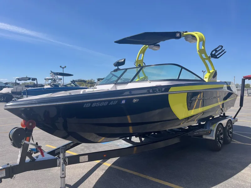 Slide: The Image of 2014 Nautique 230 TEAM EDITION boat on trailer in sunny parking lot. - 9