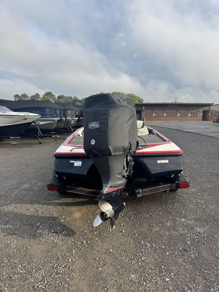 Slide: The Image of 2019 Skeeter FX20 LE boat with covered outboard motor in a parking area. - 2