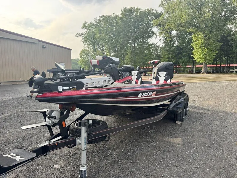Slide: The Image of 2019 Skeeter FX20 LE bass boat on trailer, parked outdoors near trees. - 5