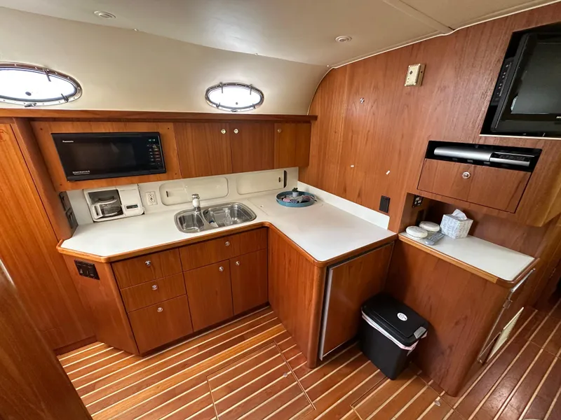 Slide: The Image of 1998 Tiara Yachts 4000 Express galley with wood cabinetry and modern appliances. - 12