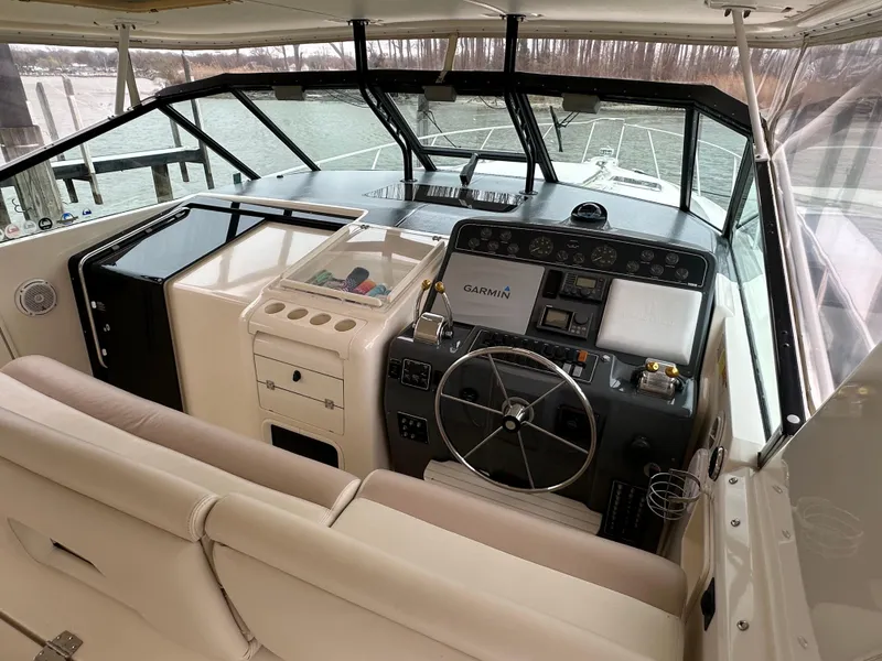 Slide: The Image of 1998 Tiara Yachts 4000 Express helm with Garmin navigation, beige seating, and panoramic windows. - 23