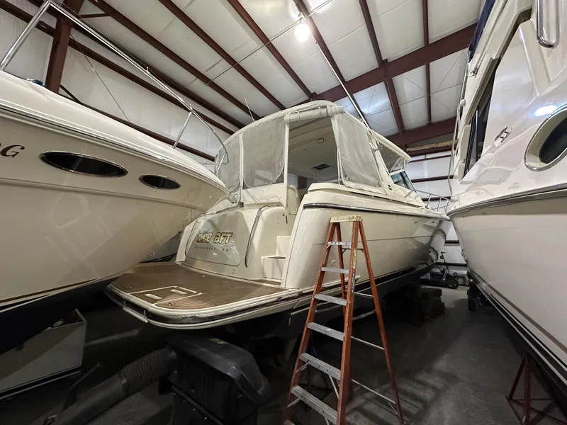 Slide: The Image of 1998 Tiara Yachts 4000 Express in storage, surrounded by other boats, with a ladder nearby. - 29