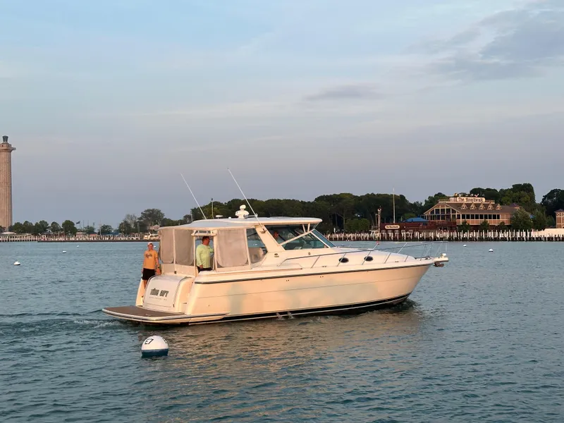 Slide: The Image of 1998 Tiara Yachts 4000 Express cruising on calm waters near a scenic shoreline. - 3