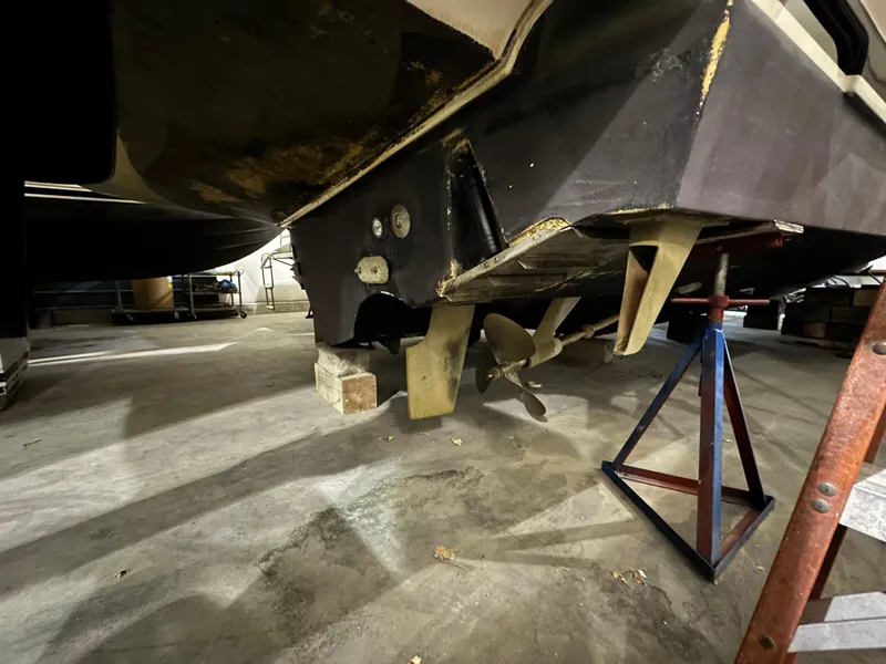 Slide: The Image of 1998 Tiara Yachts 4000 Express underbody with propeller and support stands in a workshop. - 30