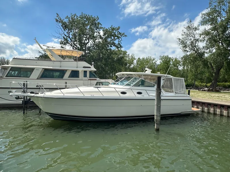 Slide: The Image of 1998 Tiara Yachts 4000 Express docked in a serene marina setting. - 4