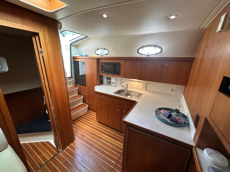 Slide: The Image of 1998 Tiara Yachts 4000 Express interior with wooden cabinetry and modern kitchen amenities. - 43