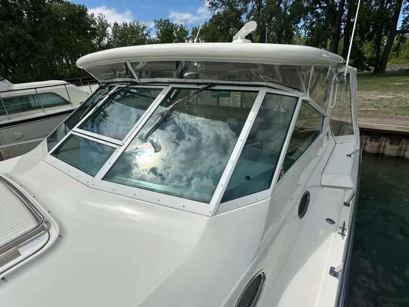 Slide: The Image of 1998 Tiara Yachts 4000 Express with sleek design and reflective windows. - 47