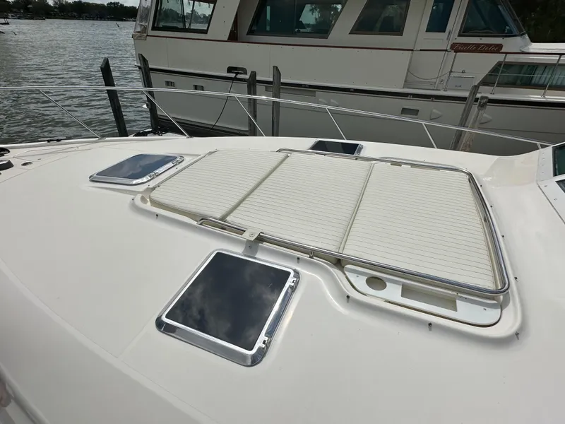 Slide: The Image of 1998 Tiara Yachts 4000 Express boat deck with hatches, docked by the water. - 48