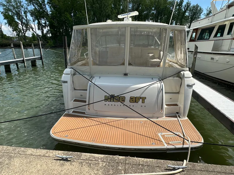 Slide: The Image of 1998 Tiara Yachts 4000 Express docked, rear view with teak swim platform. - 7