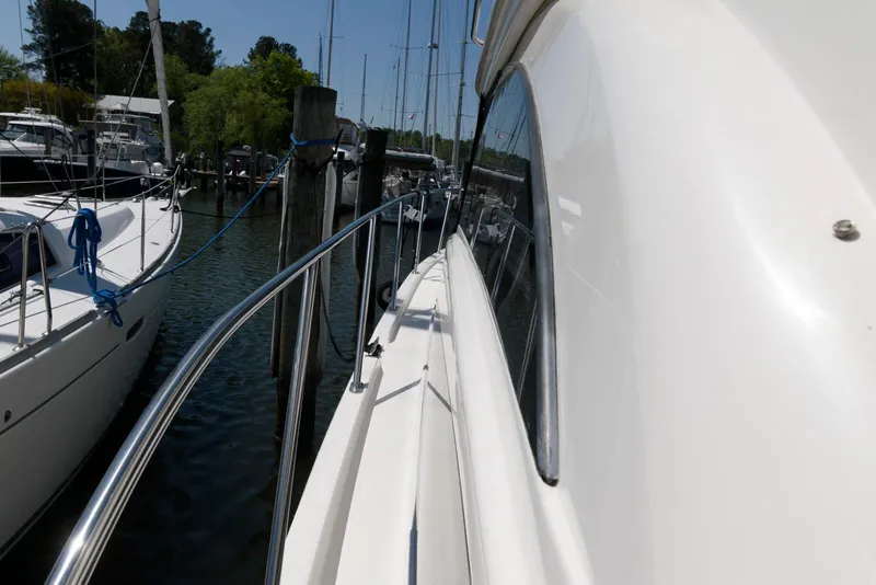 Slide: The Image of 2007 Meridian 341 Sedan yacht docked at marina, side view with railing and nearby boats. - 4