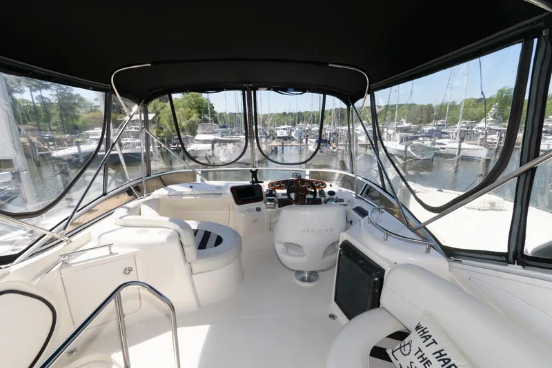 Slide: The Image of 2007 Meridian 341 Sedan yacht interior with helm, marina view, and seating area. - 5