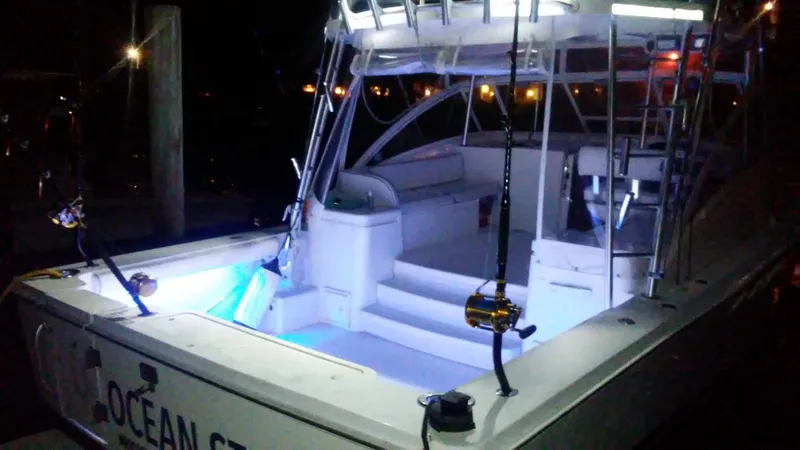 Slide: The Image of 2000 Luhrs 36 SX boat illuminated at night, showcasing fishing equipment and seating area. - 3
