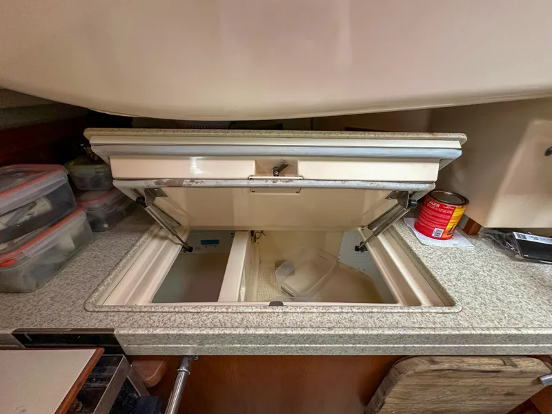 Slide: The Image of Open storage compartment in 2005 Island Packet 370 yacht kitchen with organized containers. - 14