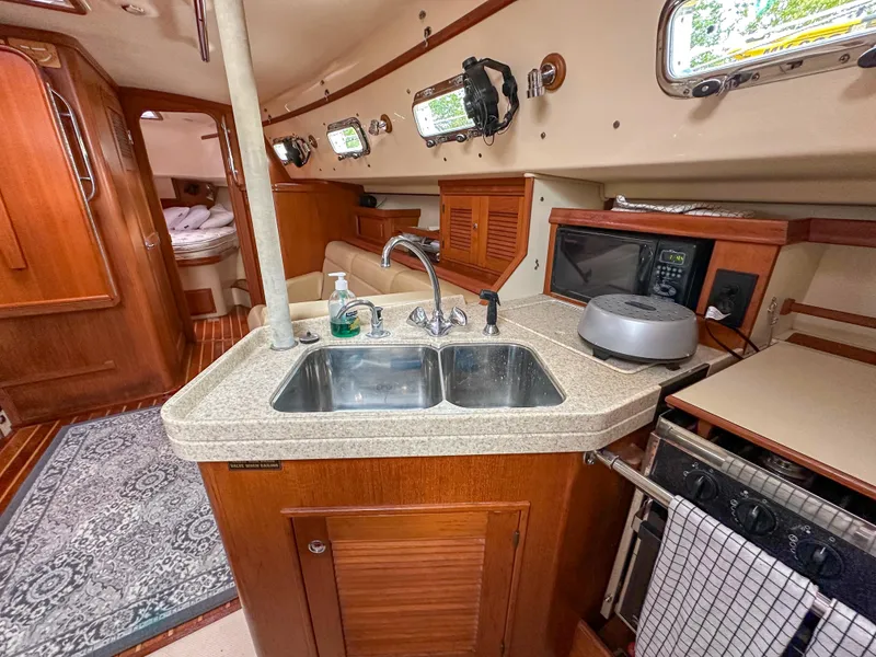 Slide: The Image of 2005 Island Packet 370 yacht interior with kitchen sink, stove, and microwave. - 19