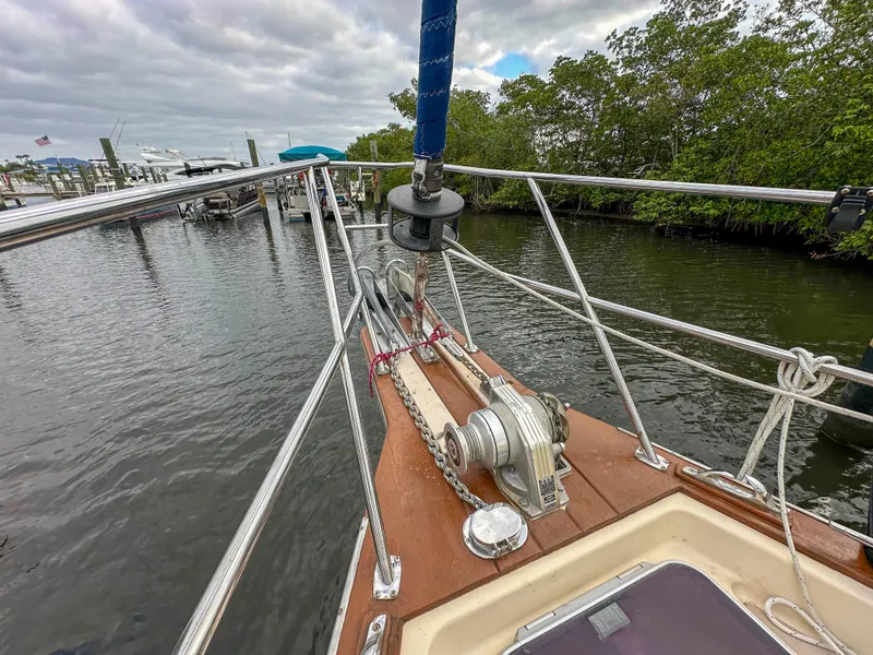 Slide: The Image of Bow view of 2005 Island Packet 370 sailboat docked near lush greenery. - 5