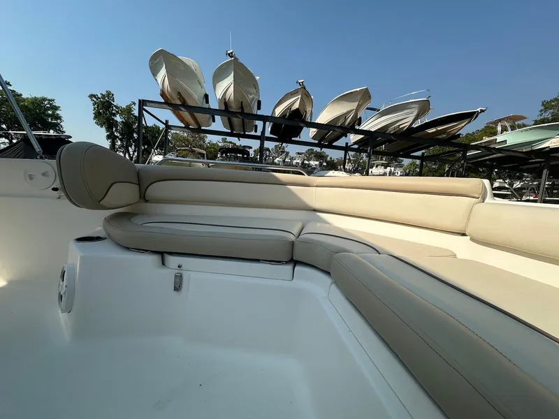 Slide: The Image of 2021 NauticStar 211 Hybrid boat with beige seating, docked under clear blue sky. - 10