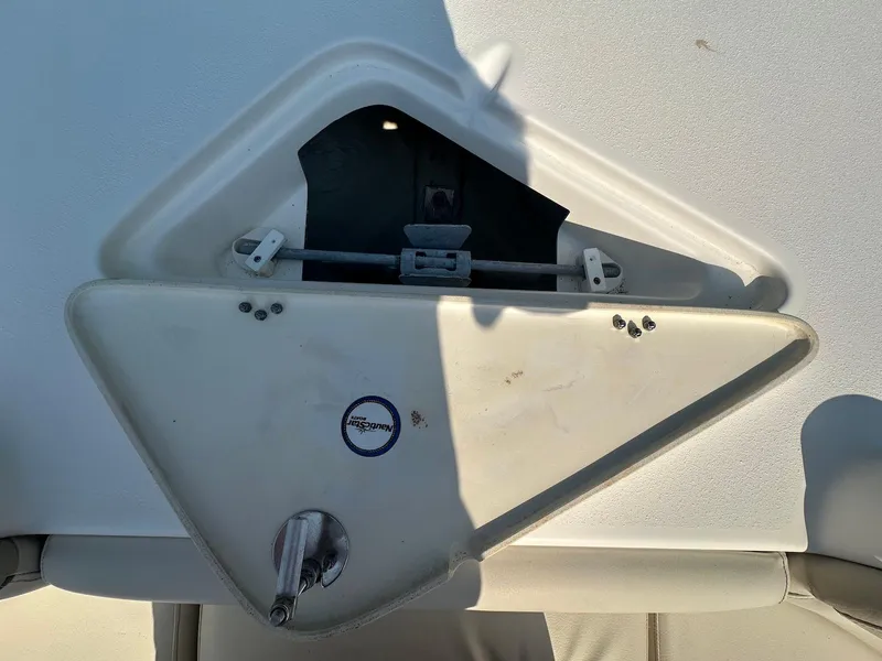 Slide: The Image of 2021 NauticStar 211 Hybrid boat compartment with open hatch and latch mechanism. - 12