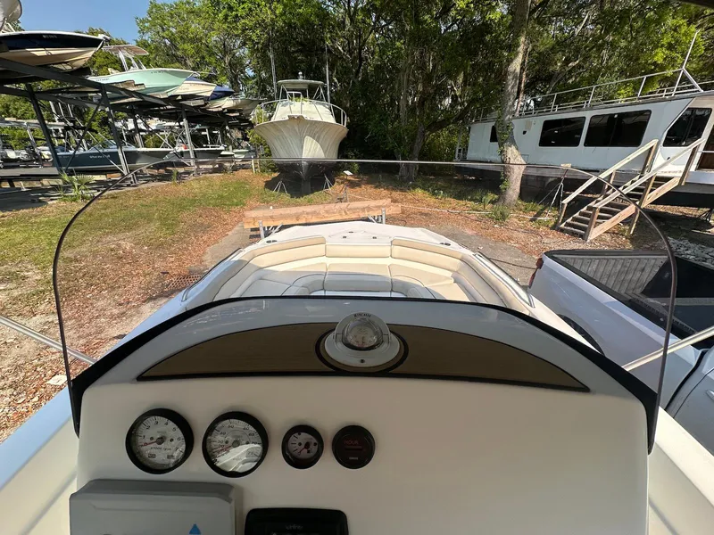 Slide: The Image of 2021 NauticStar 211 Hybrid boat dashboard view, parked outdoors near other boats. - 17
