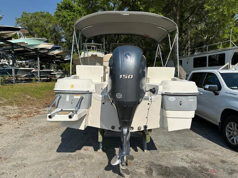 Slide: The Image of 2021 NauticStar 211 Hybrid boat with 150 HP engine, parked outdoors. - 18