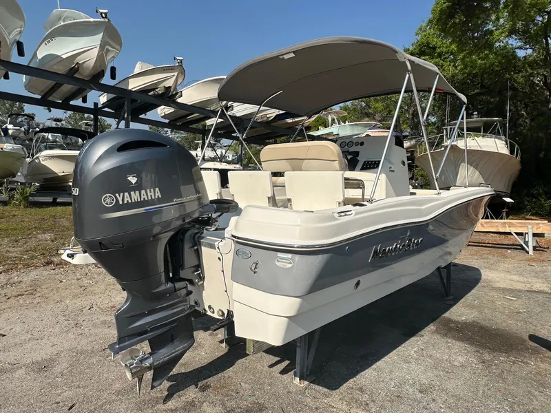 Slide: The Image of 2021 NauticStar 211 Hybrid boat with Yamaha engine, parked outdoors under a canopy. - 19