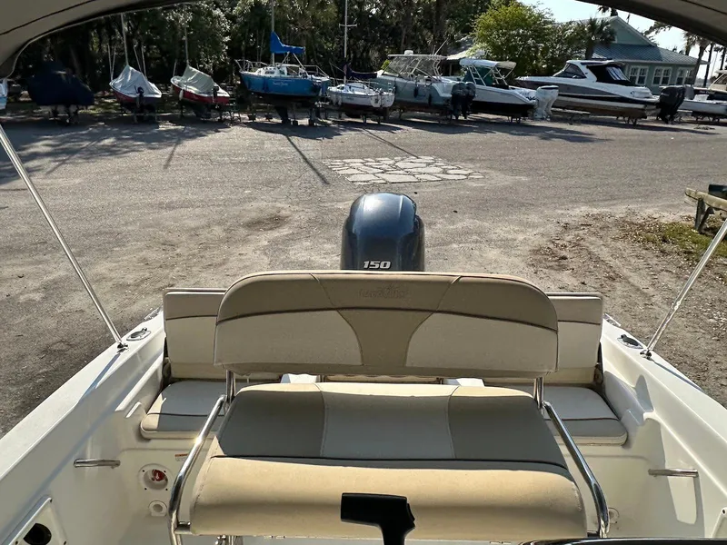 Slide: The Image of 2021 NauticStar 211 Hybrid boat with Yamaha 150 engine, docked at a marina. - 20