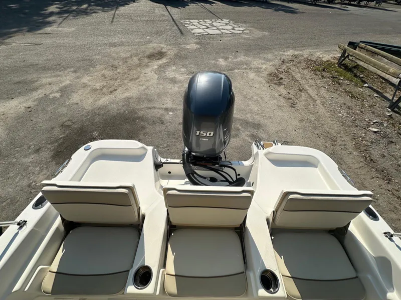 Slide: The Image of 2021 NauticStar 211 Hybrid boat with three seats and a 150 HP outboard motor. - 21