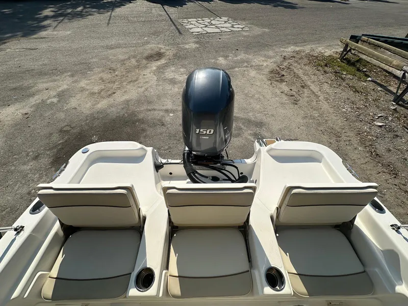 Slide: The Image of 2021 NauticStar 211 Hybrid boat with three rear seats and a 150 HP outboard motor. - 22