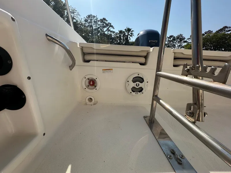 Slide: The Image of 2021 NauticStar 211 Hybrid boat interior with railing and engine view. - 24