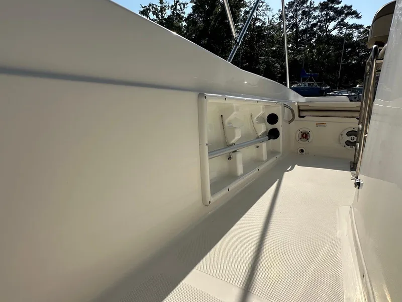 Slide: The Image of 2021 NauticStar 211 Hybrid boat interior with rod holders and storage compartments. - 27