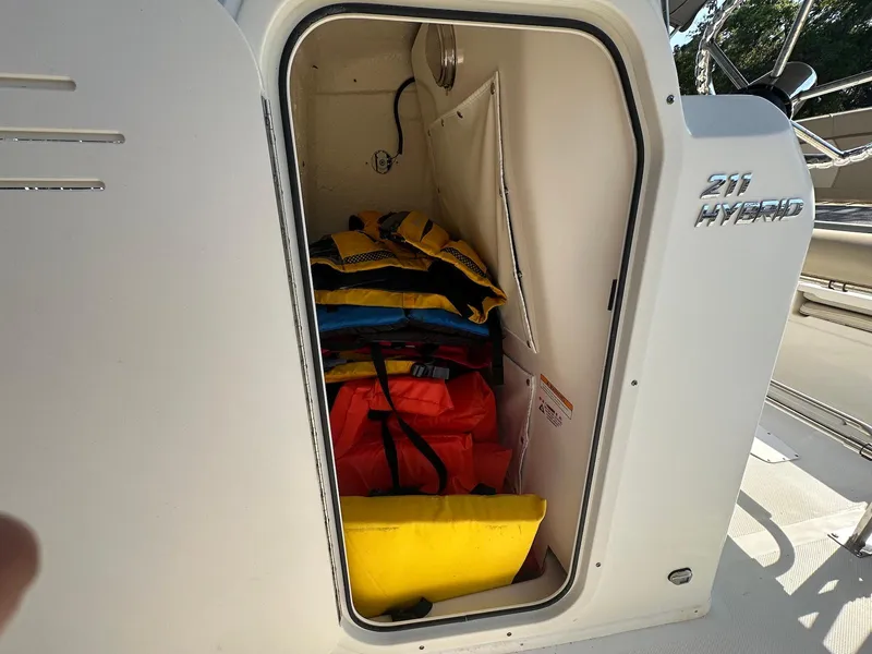 Slide: The Image of Storage compartment on a 2021 NauticStar 211 Hybrid boat with life jackets inside. - 29
