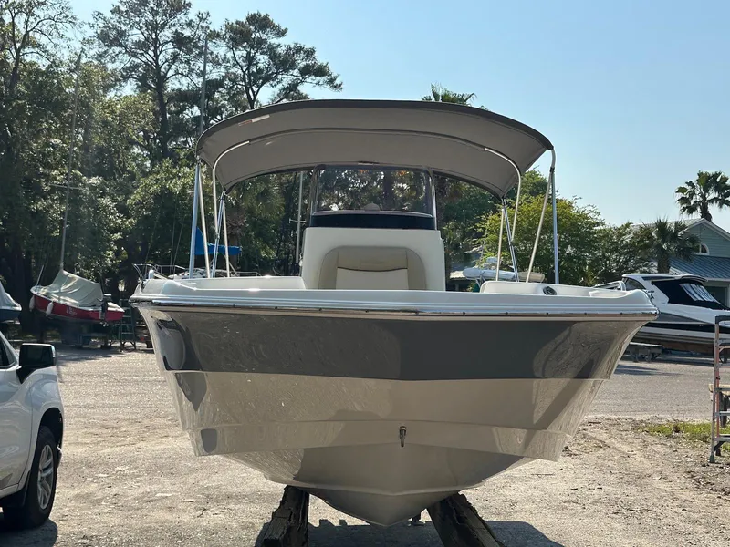 Slide: The Image of 2021 NauticStar 211 Hybrid boat with canopy, parked outdoors. - 3