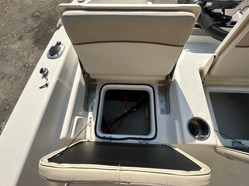 Slide: The Image of 2021 NauticStar 211 Hybrid boat seat storage compartment open, revealing interior space. - 32
