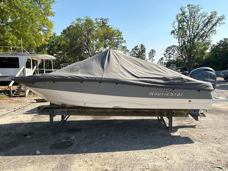 Slide: The Image of 2021 NauticStar 211 Hybrid boat covered, parked outdoors. - 4