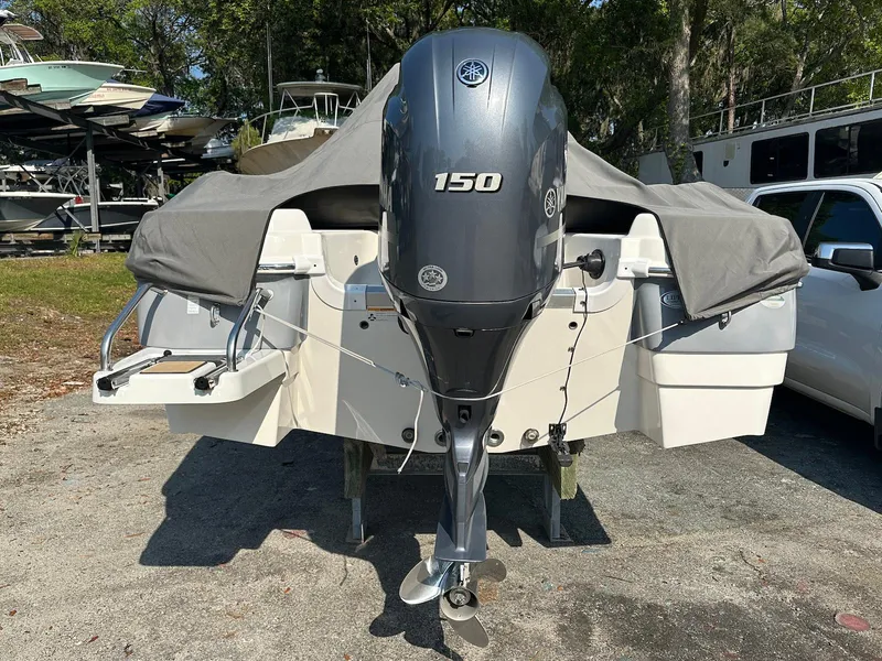 Slide: The Image of 2021 NauticStar 211 Hybrid boat with Yamaha 150 outboard motor, parked outdoors. - 5