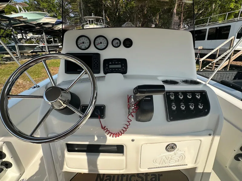 Slide: The Image of 2021 NauticStar 211 Hybrid boat dashboard with steering wheel and control panel. - 7