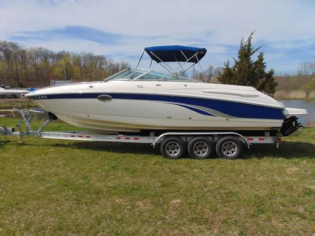 The Image of 2001 Chaparral 280SSi boat on trailer with blue canopy, parked on grass. - 1