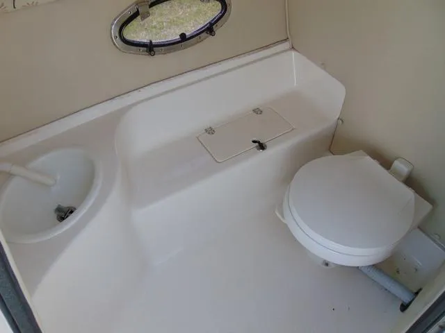 Slide: The Image of 2001 Chaparral 280SSi boat bathroom with sink, toilet, and porthole window. - 13